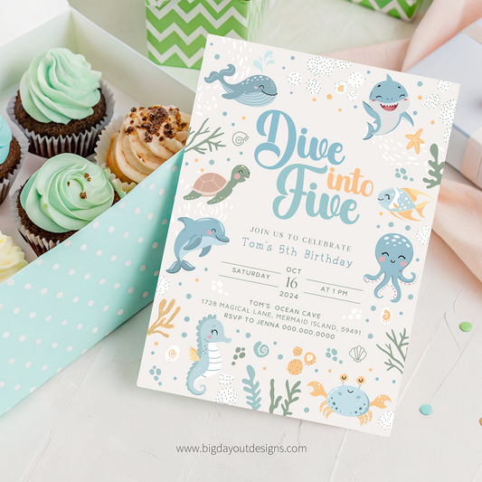 Underwater-themed birthday invitation with cupcakes on a light surface