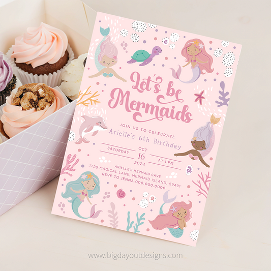 Mermaid-themed birthday invitation card with cupcakes on a white surface