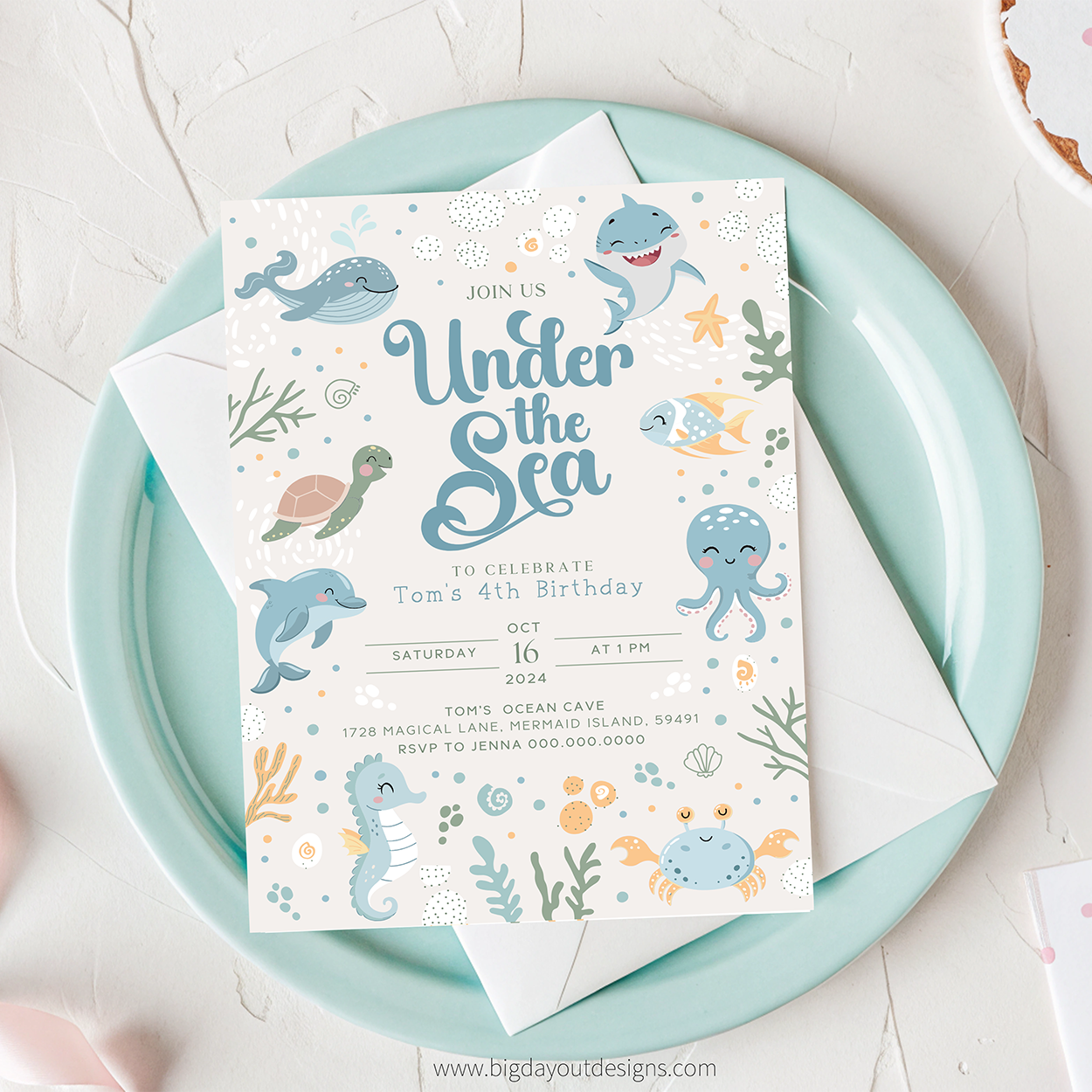 Under the Sea birthday invitation on a light blue plate with ocean-themed illustrations.