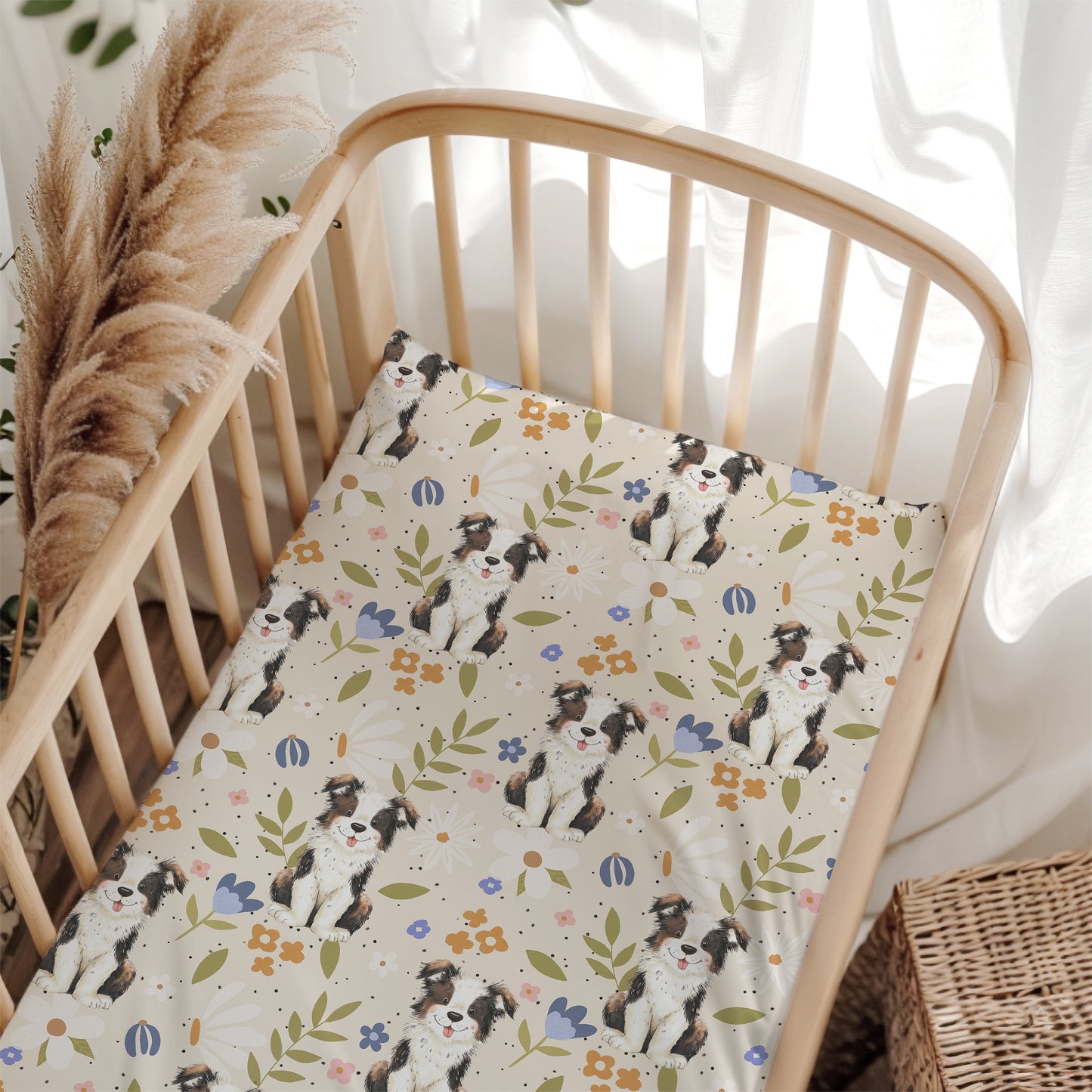 Crib with a patterned sheet featuring dogs and flowers, surrounded by decorative elements.