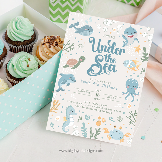 Under the sea birthday party invitation with cupcakes on a white surface