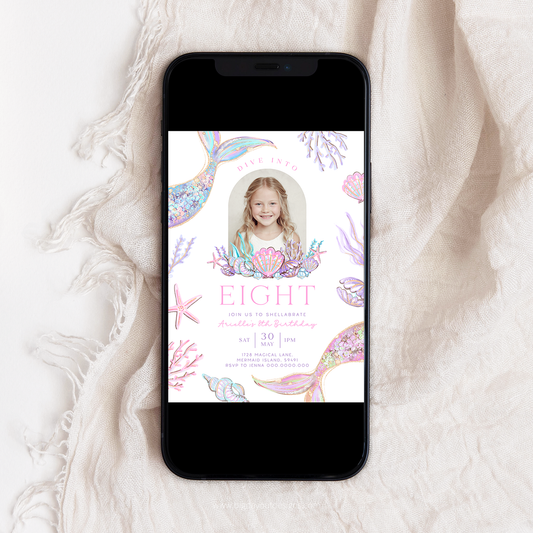 Phone displaying a birthday invitation with mermaid design on a textured white surface