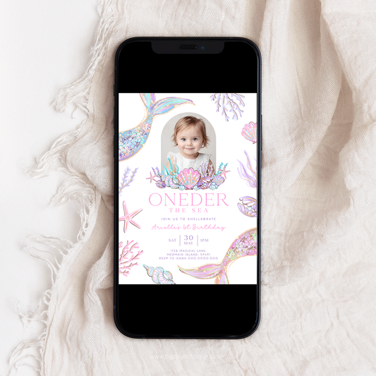 Phone displaying a birthday invitation with a mermaid theme on a textured white surface