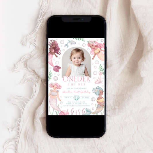 Phone displaying a mermaid-themed birthday invitation on a textured white surface