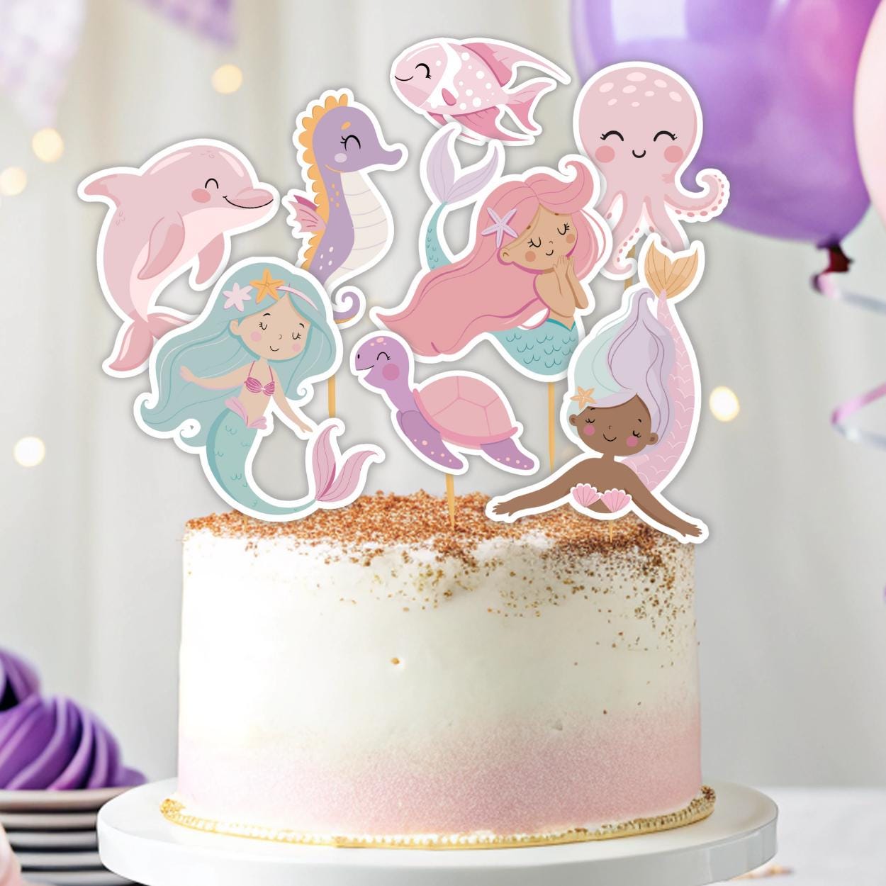Cake with mermaid and sea creature toppers on a white background
