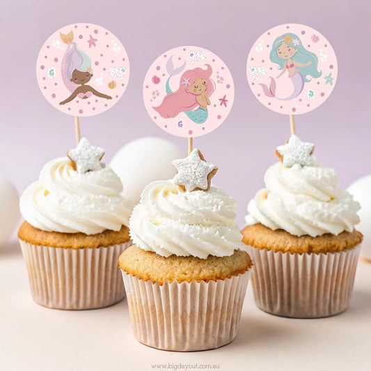 Cupcakes with mermaid-themed toppers on a light purple background