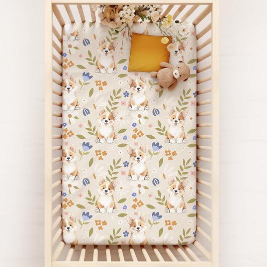 Crib with floral corgi dog cottagecore patterned sheet on a white background