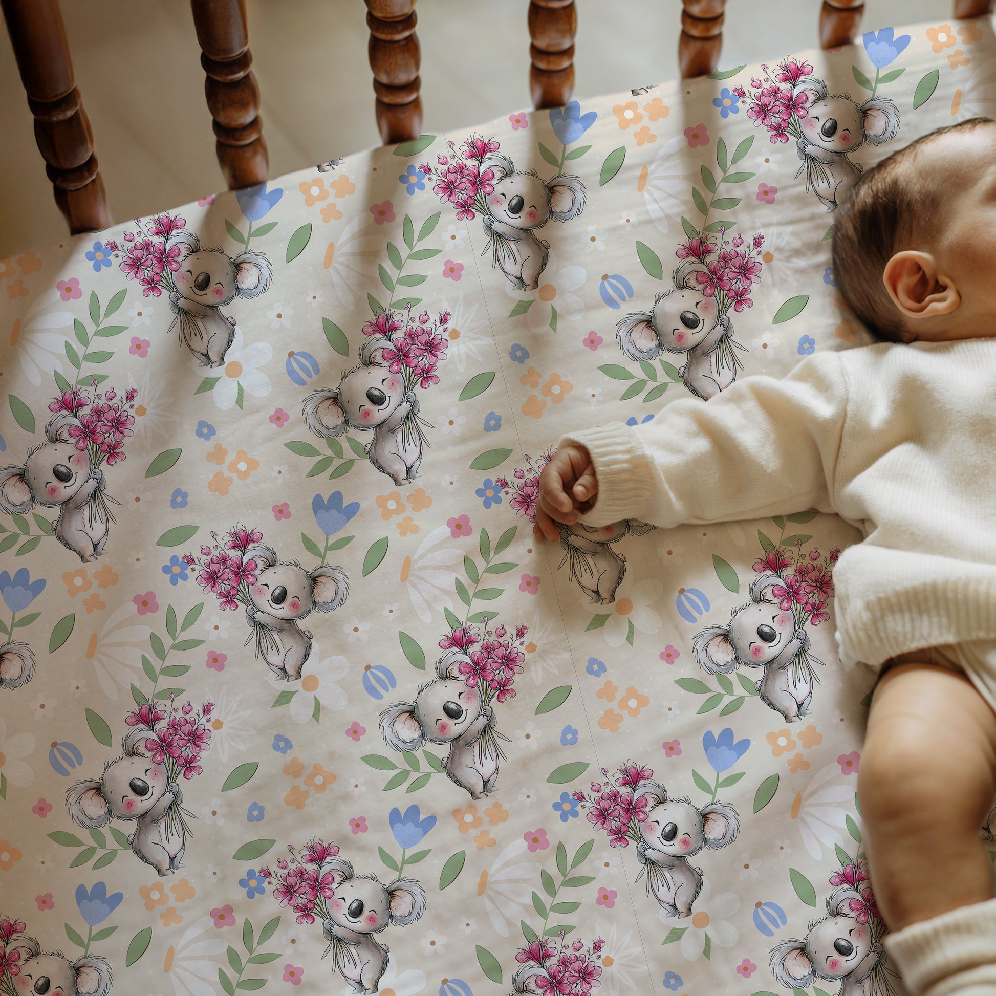 Baby lying on a crib sheet with koala and flower pattern