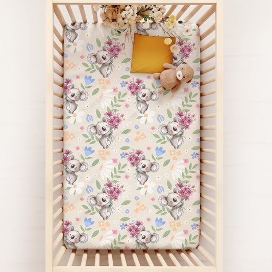 Crib with an Australian animal Koala patterned sheet on a white background
