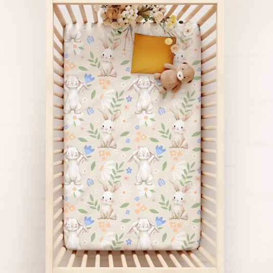 Crib with a floral and baby bunny rabbits patterned mattress cover