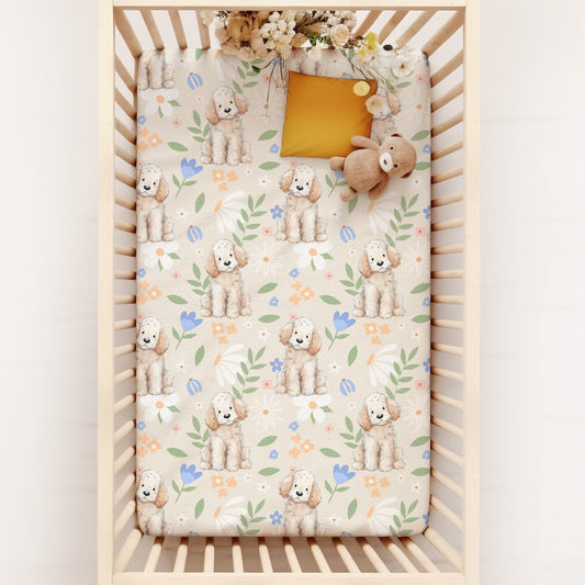 Crib with a cute poodle puppy in cottagecore style, surrounded by pastel florals and foliage -patterned mattress cover on a white background