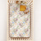 Crib with a floral and baby tiger patterned sheet