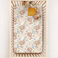 Crib with a floral and tiger patterned sheet