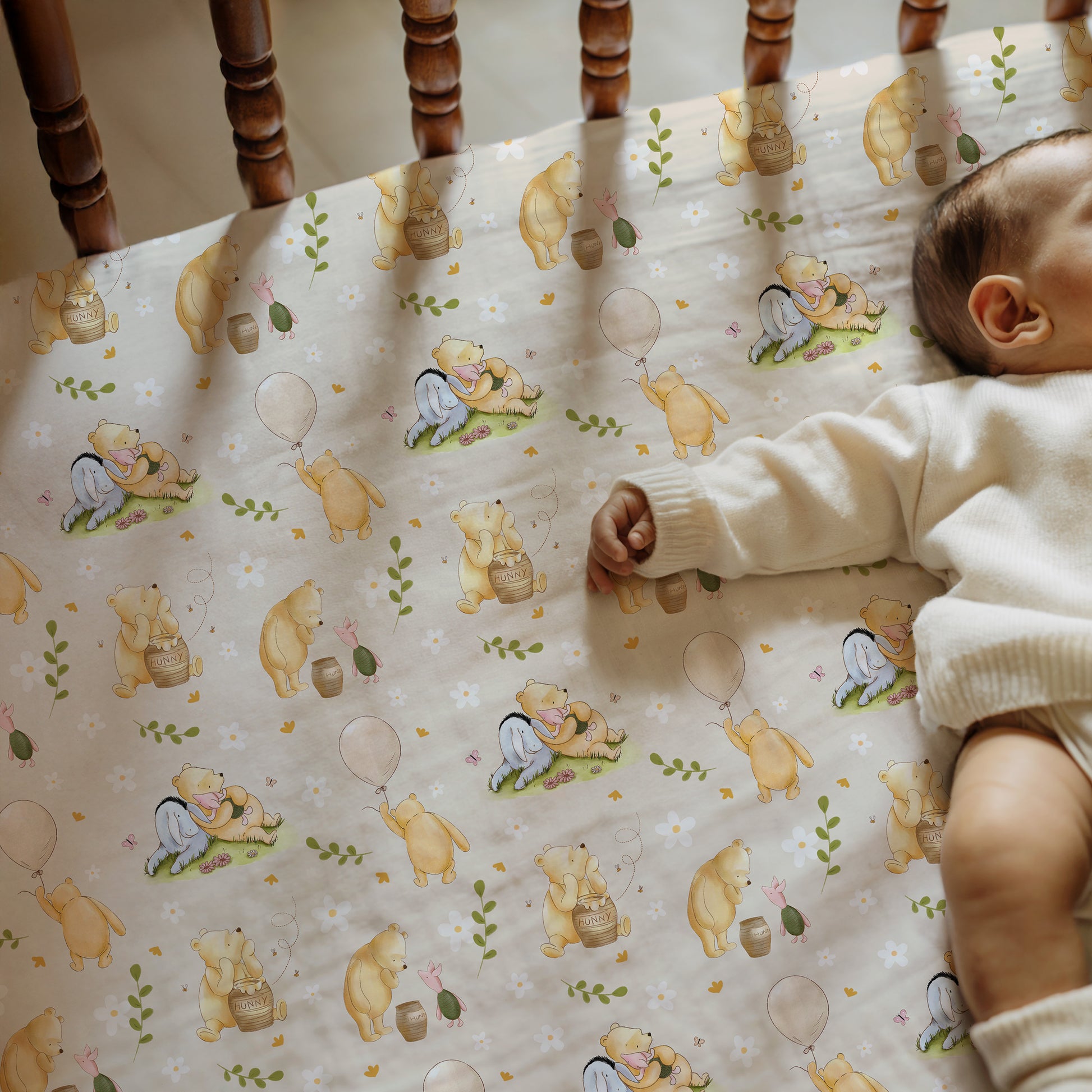 Baby lying on a crib sheet with winnie the pooh and friends 