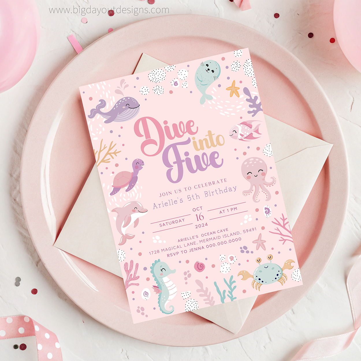 Underwater-themed birthday invitation card on a pink plate with a envelope.