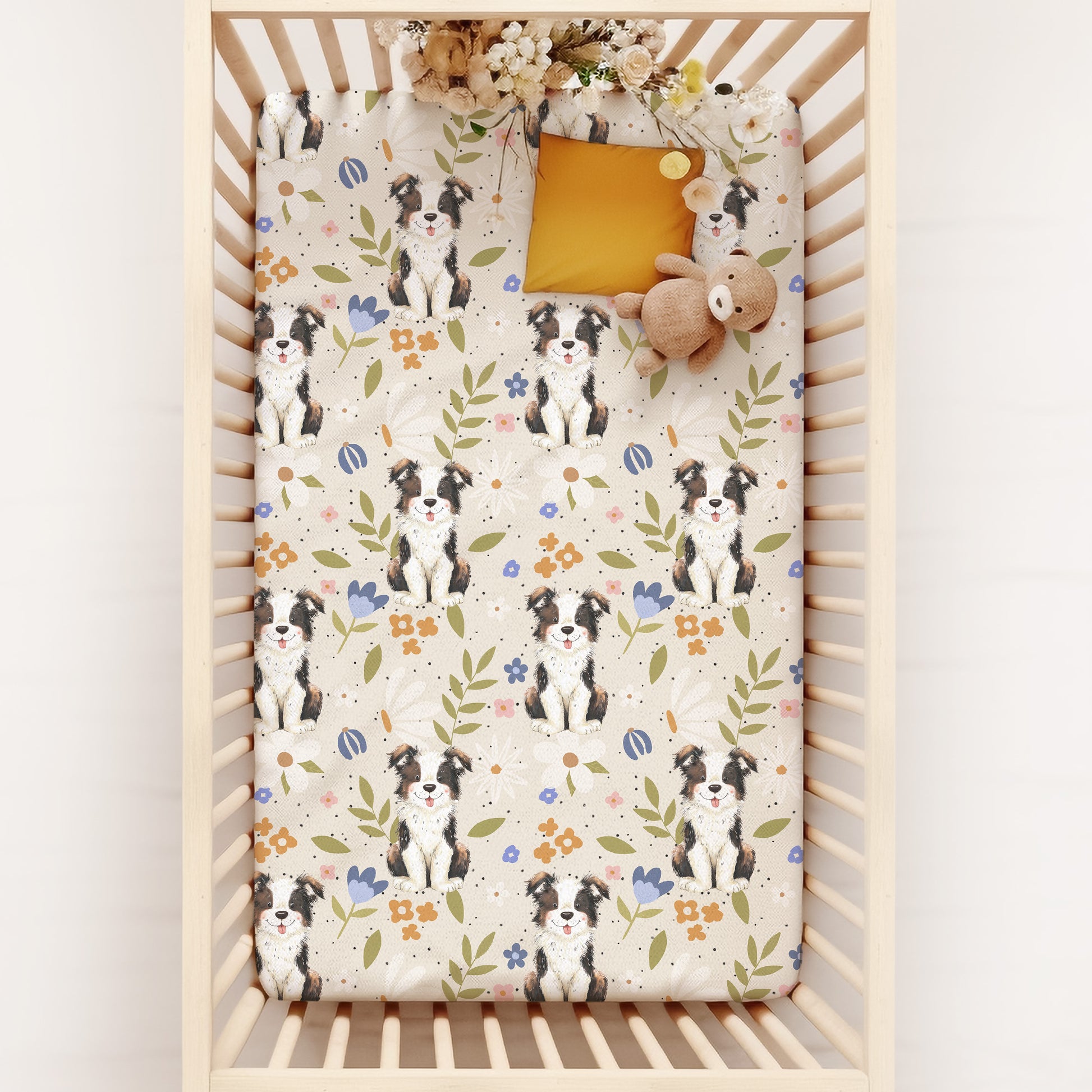 Crib with a floral and border collie sheepdog patterned crib sheet