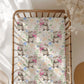 Floral patterned blanket with otter illustrations on a wooden crib