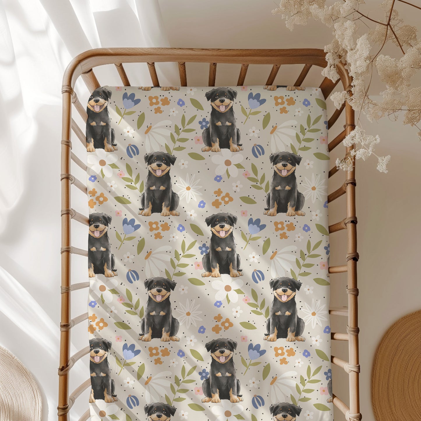 Crib with a decorative blanket featuring rottweiler puppies and floral patterns.