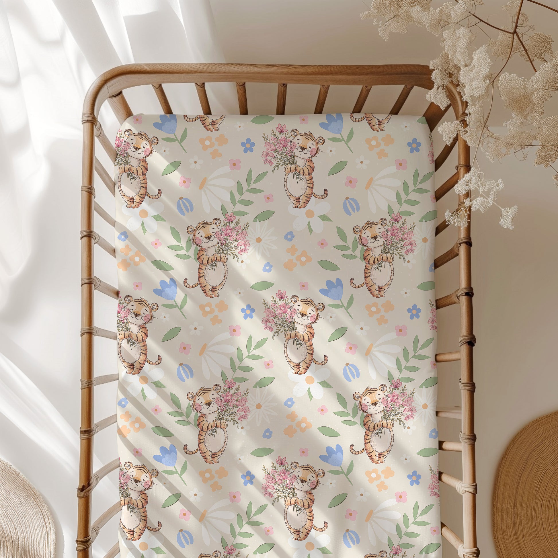 Crib with a decorative sheet featuring cartoon tigers and flowers.