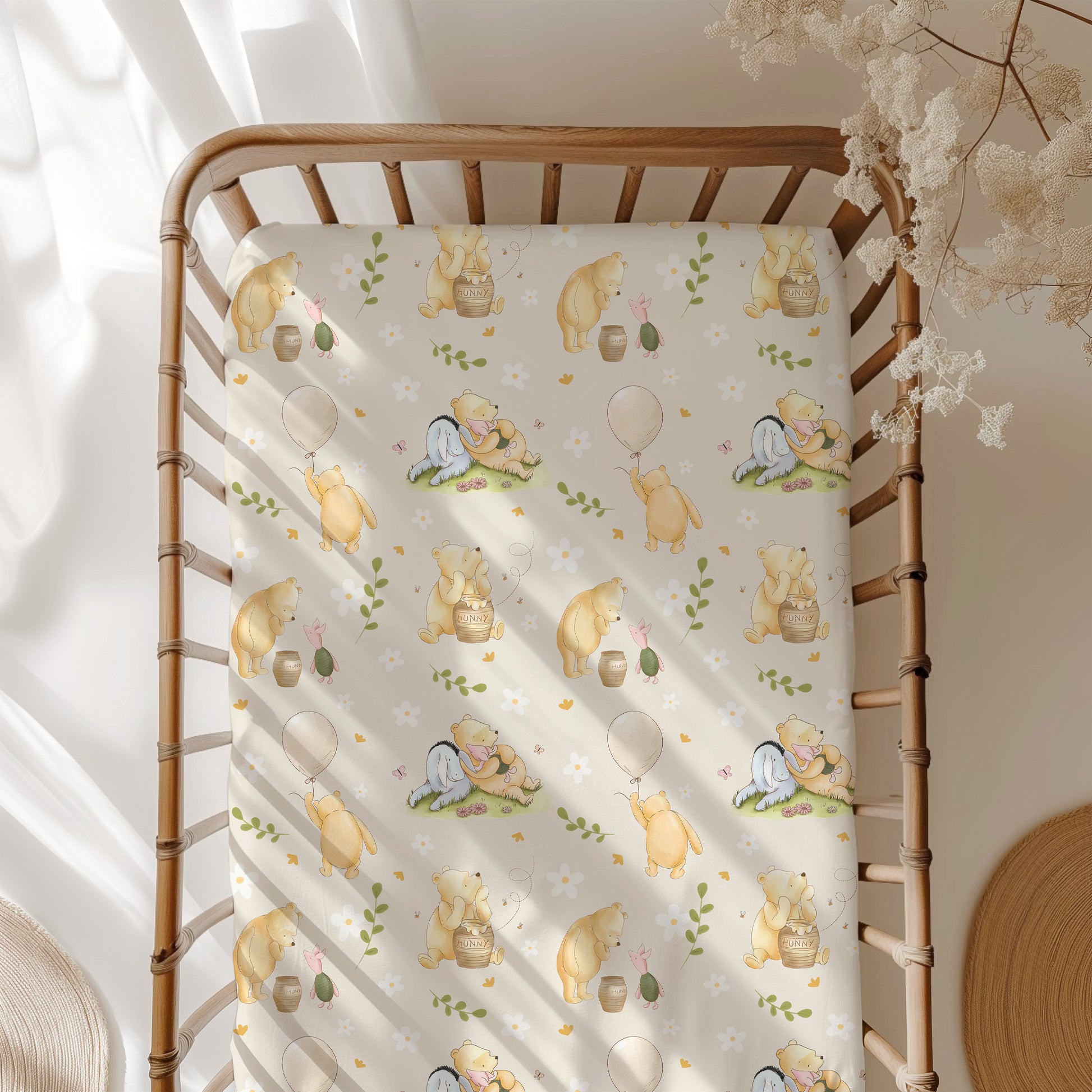 Crib with a classic Winnie the Pooh patterned sheet in a bright room.