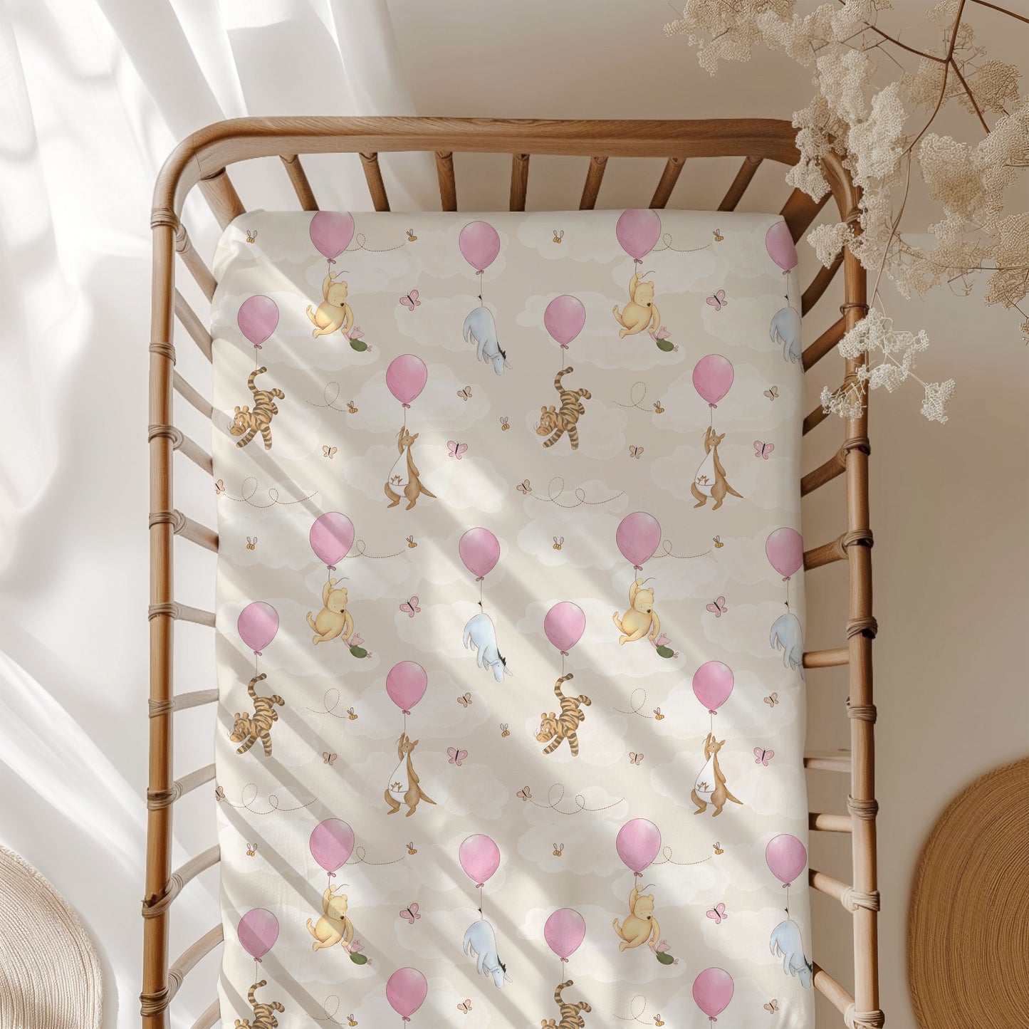 Baby crib with a Winnie the Pooh crib sheet featuring balloons and friends.
