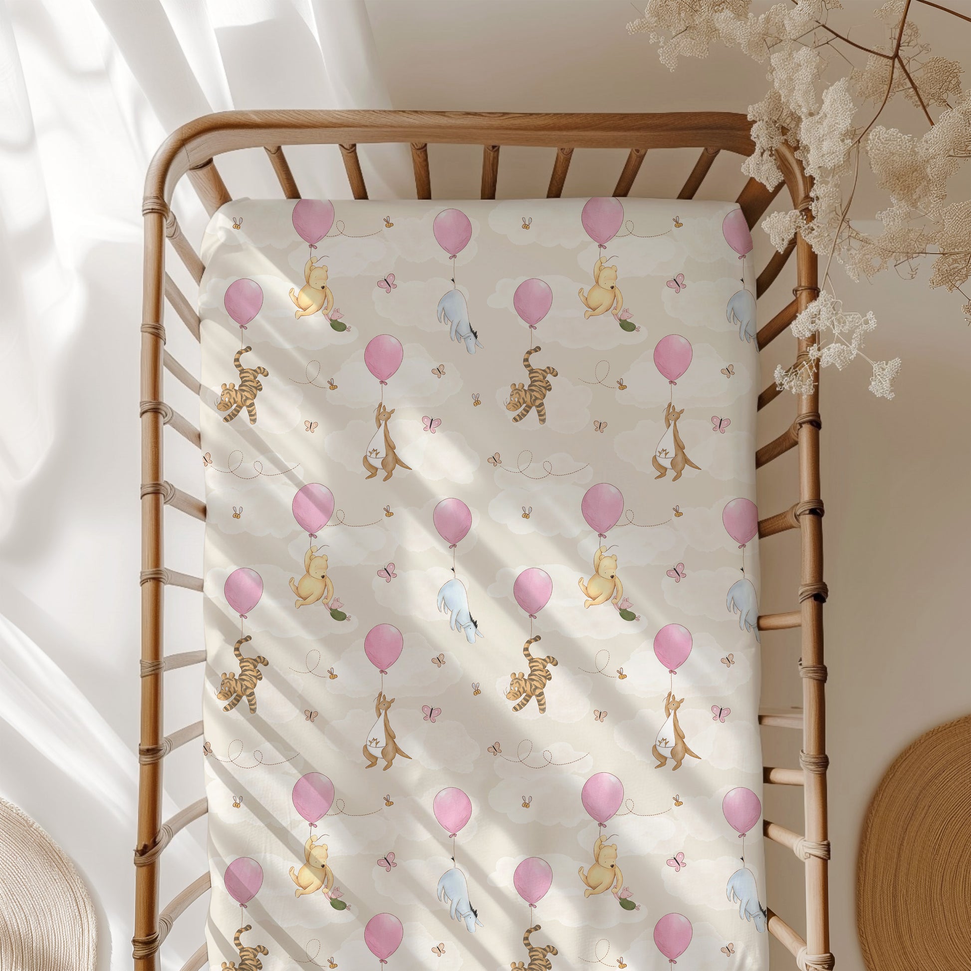 Baby crib with a Winnie the Pooh crib sheet featuring balloons and friends.