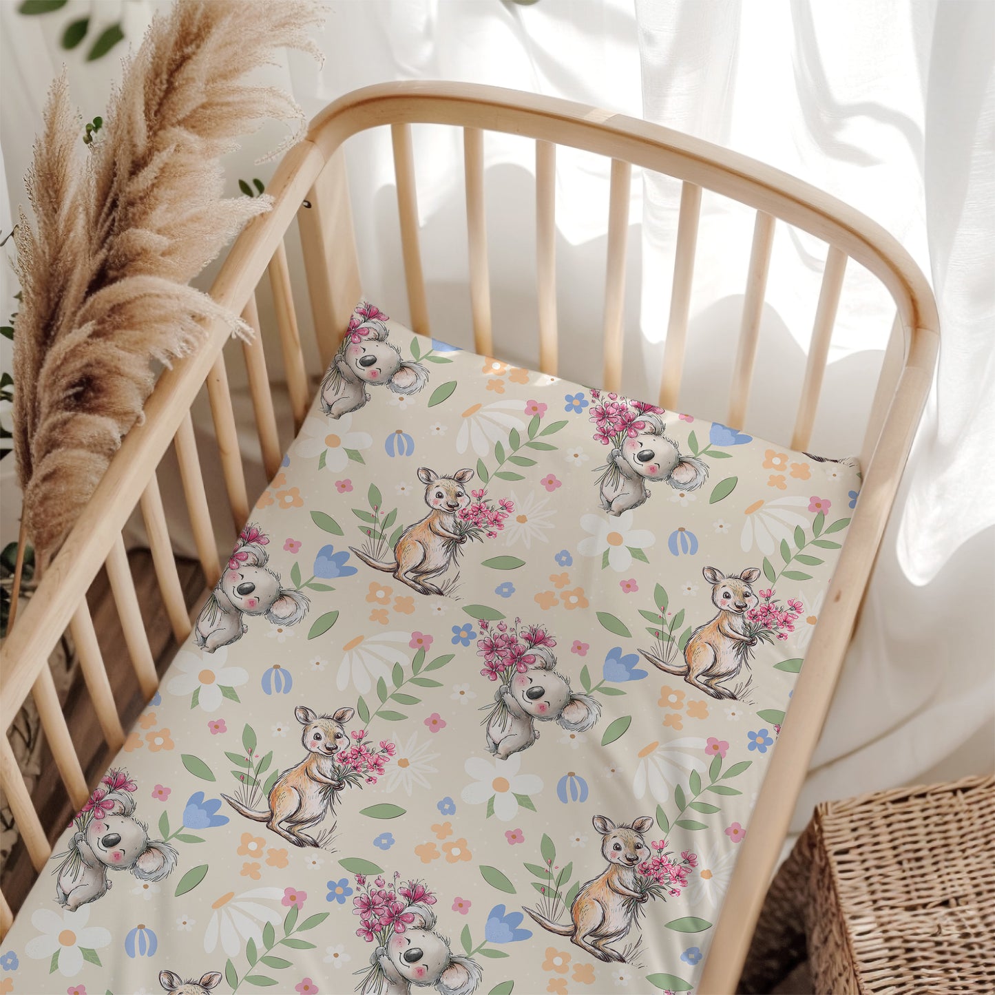 Crib with a floral and australian animal patterned sheet in a bright room.