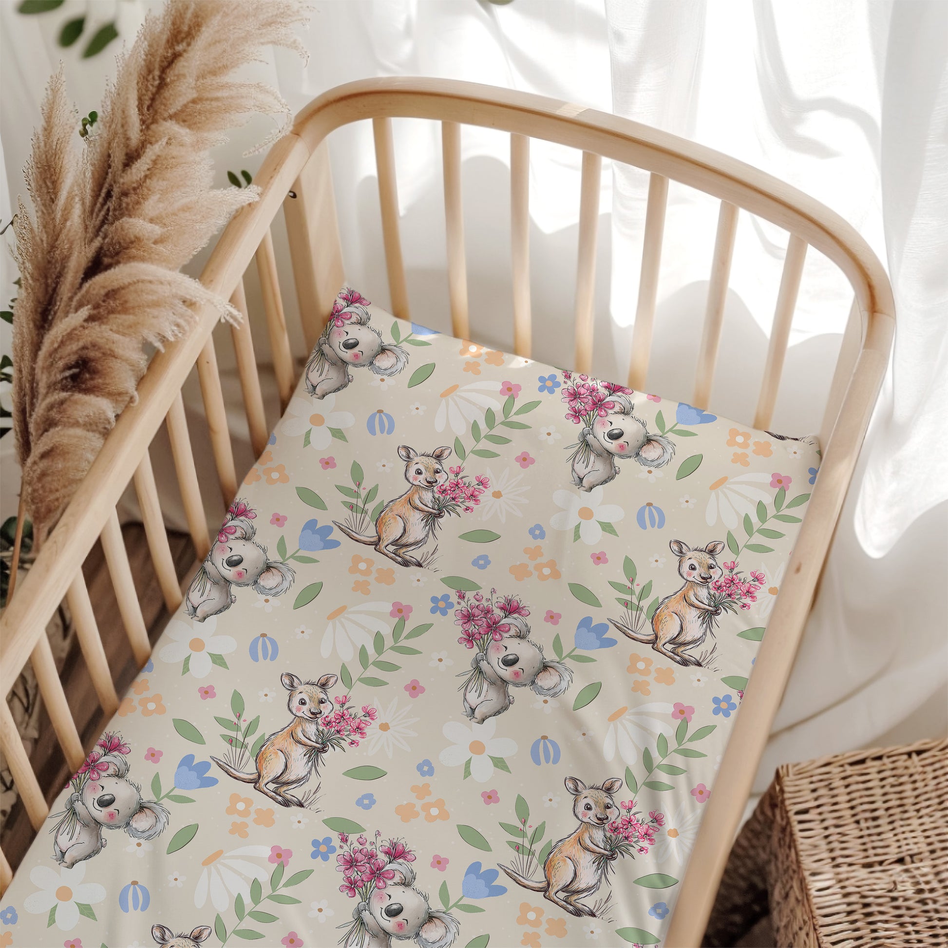 Crib with a floral and australian animal patterned sheet in a bright room.
