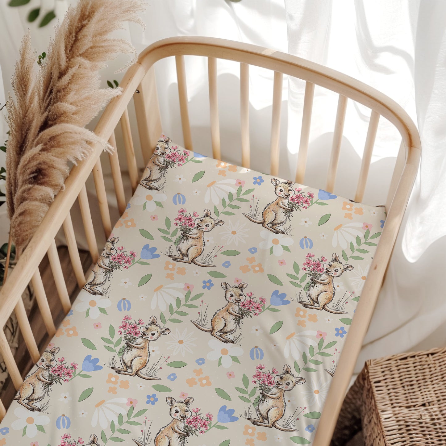 Crib with a floral and kangaroo patterned sheet, surrounded by decorative elements.