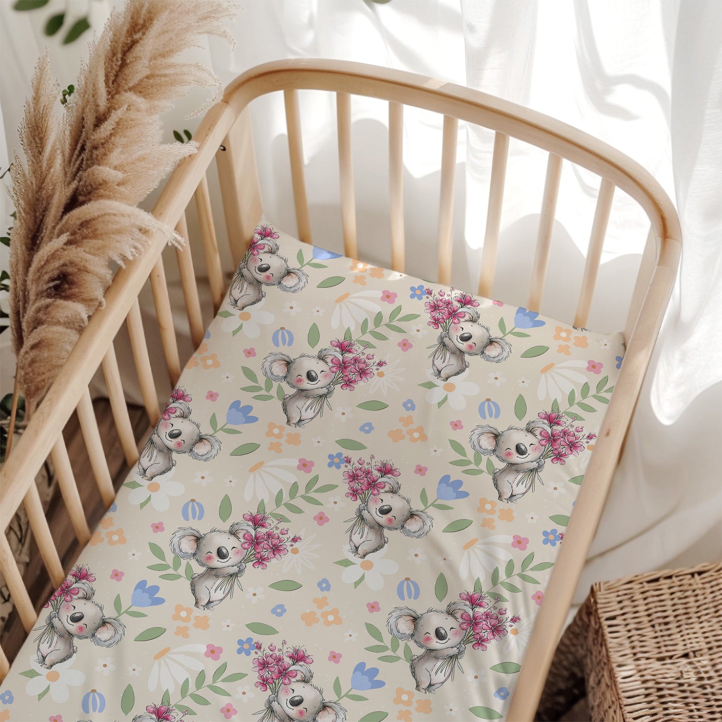 Crib with a floral and koala patterned sheet in a bright room.