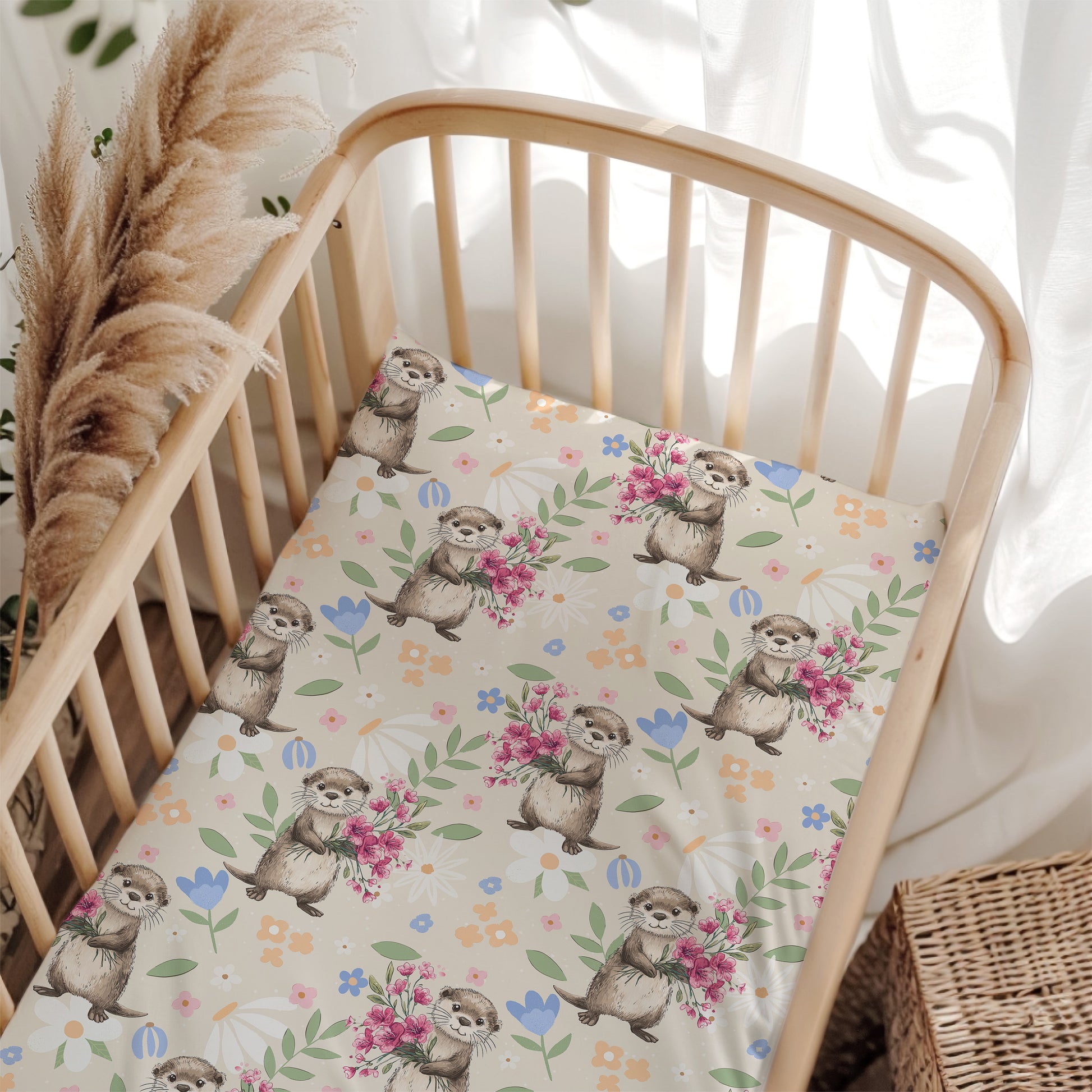 Crib with a floral and otter patterned sheet in a bright room.