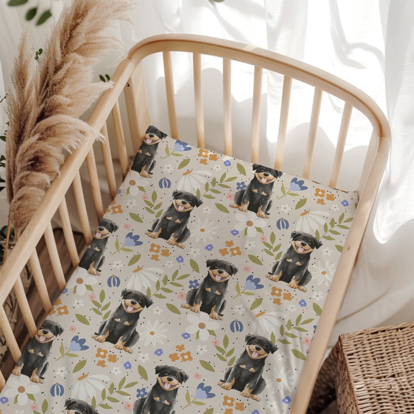 Crib with a floral patterned sheet featuring illustrations of dogs and flowers.