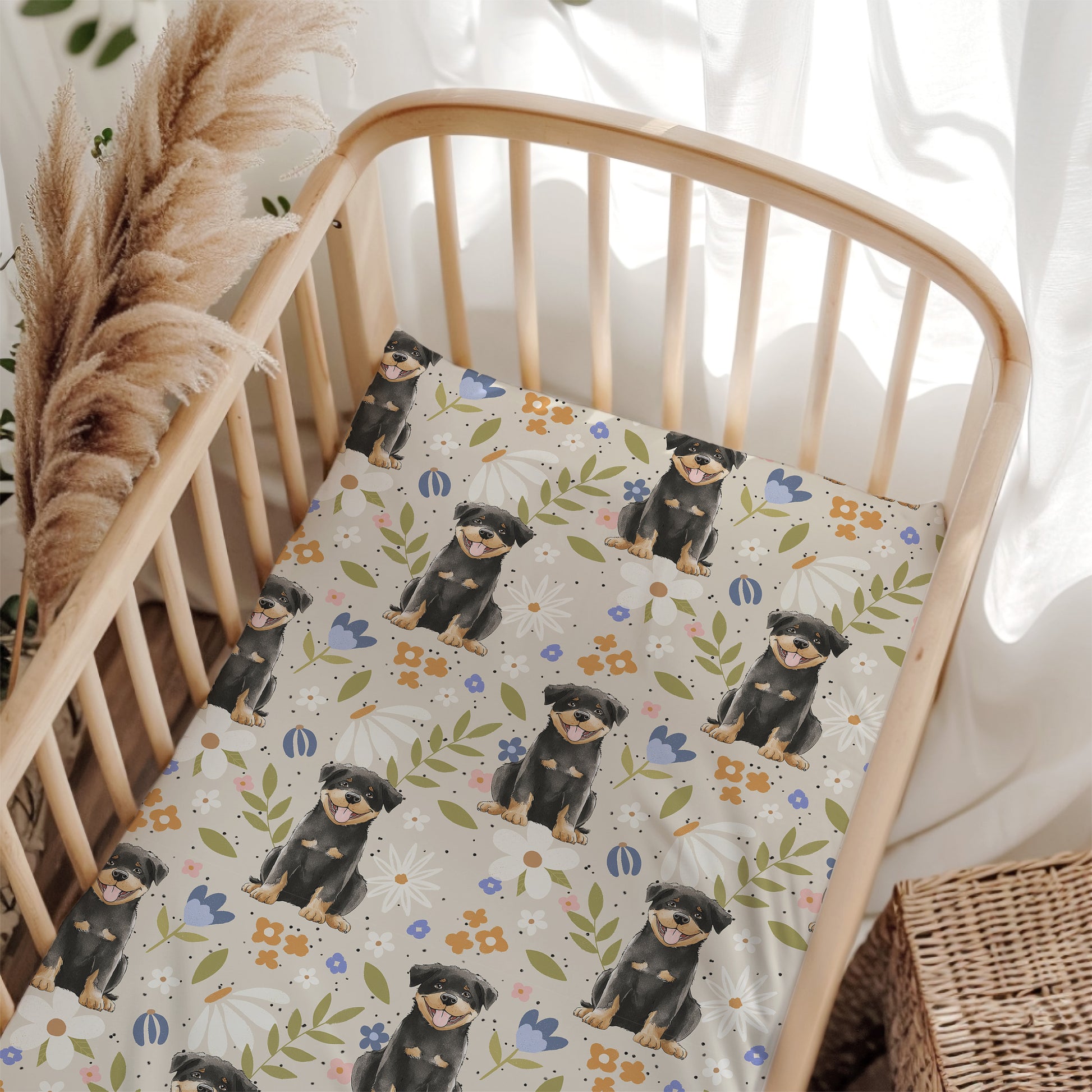Crib with a floral patterned sheet featuring illustrations of dogs and flowers.