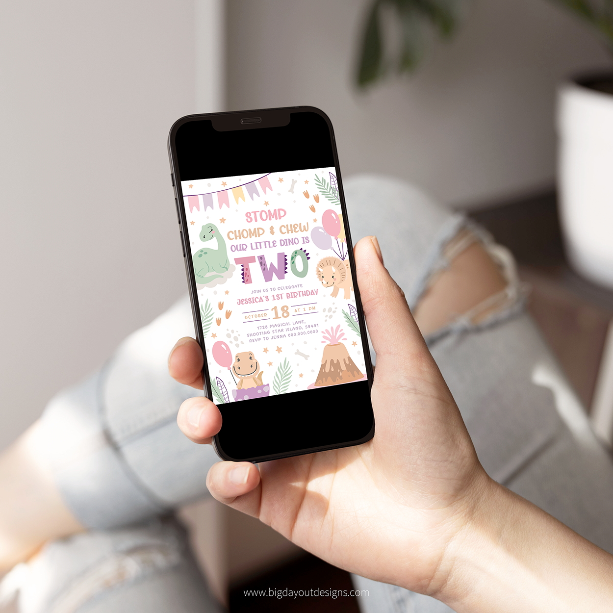 Hand holding a smartphone displaying a birthday invitation on a blurred indoor background