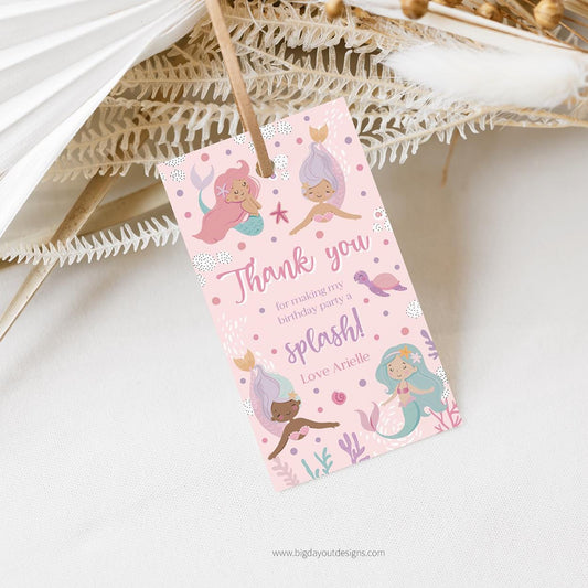 Pink gift tag with mermaid illustrations on a white background