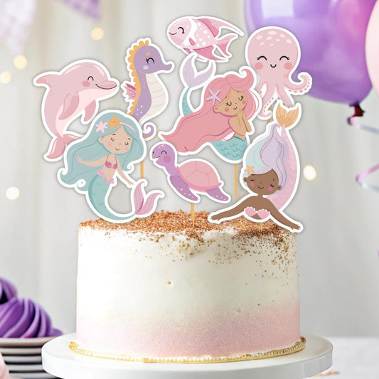 Cake with mermaid and sea creature toppers on a white background